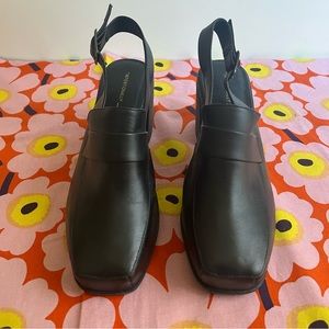 Intentionally blank sling-back black leather mules